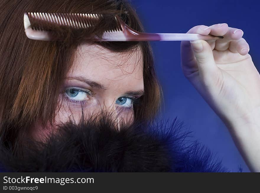 Young girl with a hairbrush and black feathers. Young girl with a hairbrush and black feathers