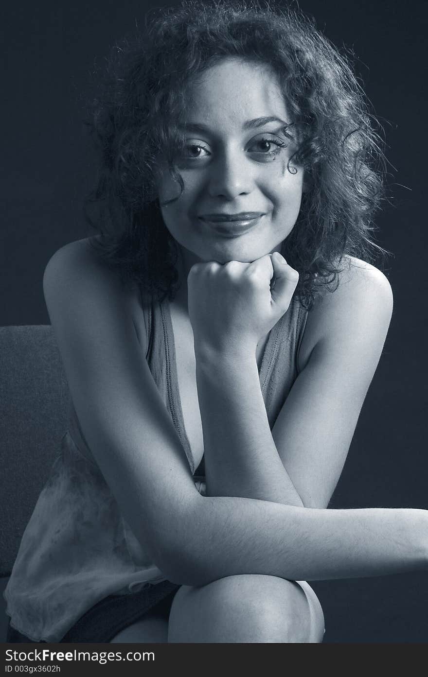 Young woman with curly hair, smiling. Young woman with curly hair, smiling