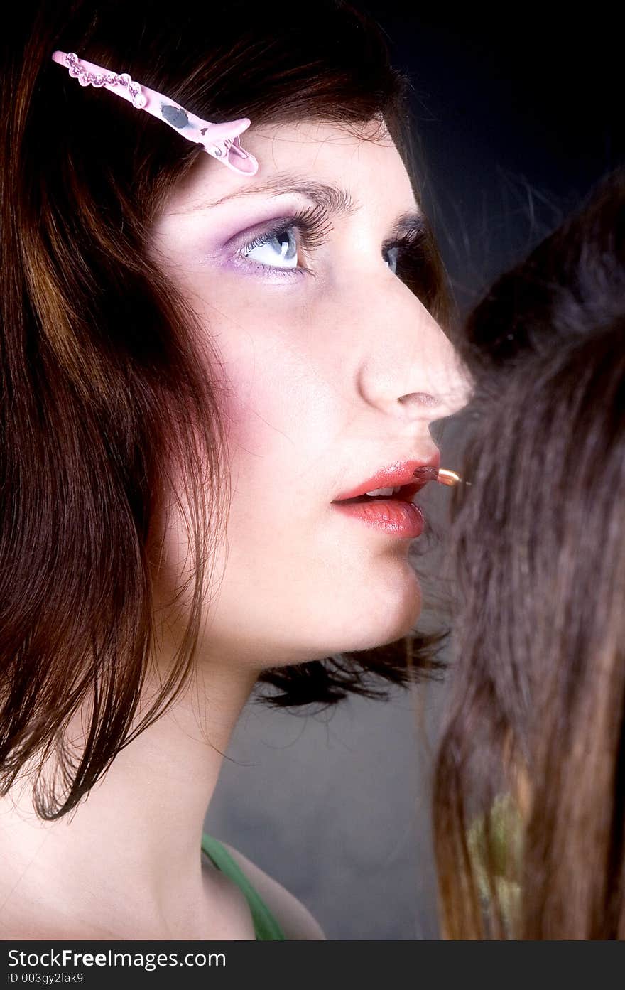 Young woman with great make-up having lipstick applied by her make-up artist. Young woman with great make-up having lipstick applied by her make-up artist