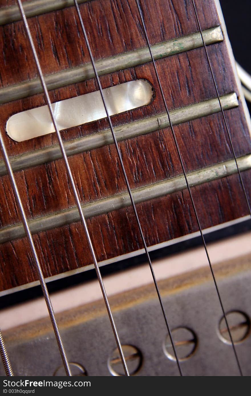 Close up of the fret board and pick up of an old guitar, conceptual quality. Close up of the fret board and pick up of an old guitar, conceptual quality