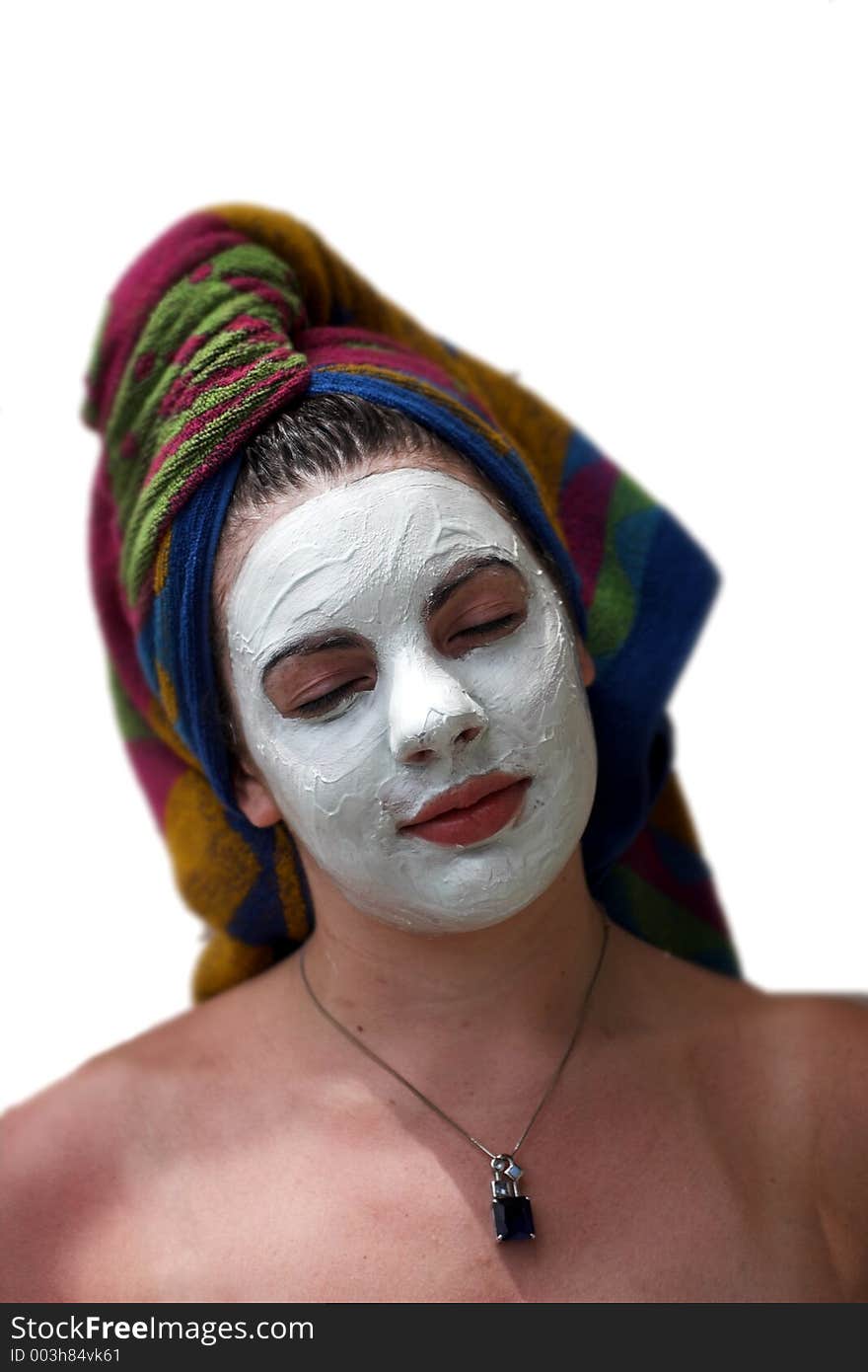 A young woman relaxes while having a facial treatment.