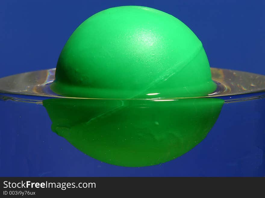 Closeup of a green ball than floats in a water glass,. Closeup of a green ball than floats in a water glass,