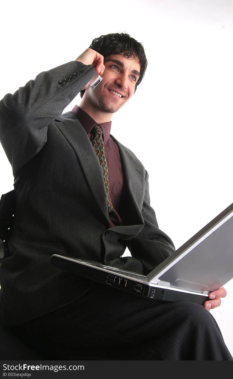 Businessman working on laptop talking on the phone