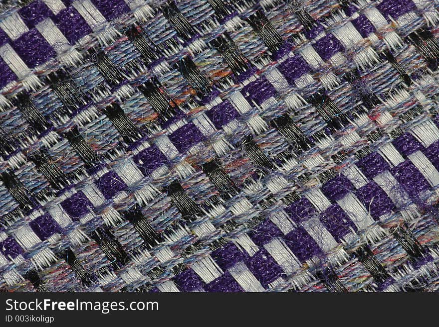 Extreme close-up of the weave of a man's tweed-style tie, revealing the secret of the fabric's subtle shades. Extreme close-up of the weave of a man's tweed-style tie, revealing the secret of the fabric's subtle shades