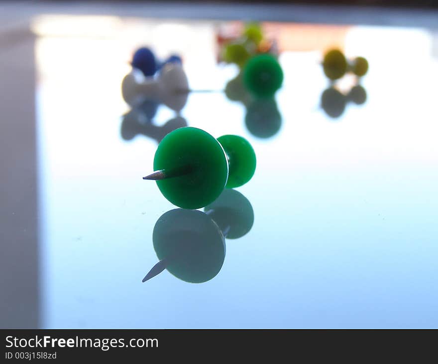 Shot of tacks on reflective surface. DOF.