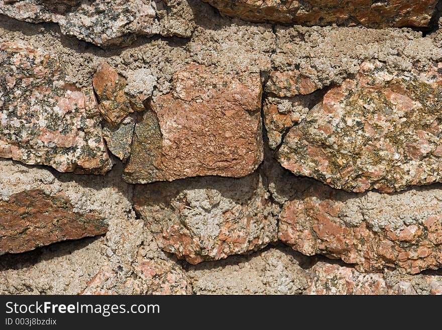 Closeup details of a moss rock wall with cement chinking for badkground uses. Closeup details of a moss rock wall with cement chinking for badkground uses