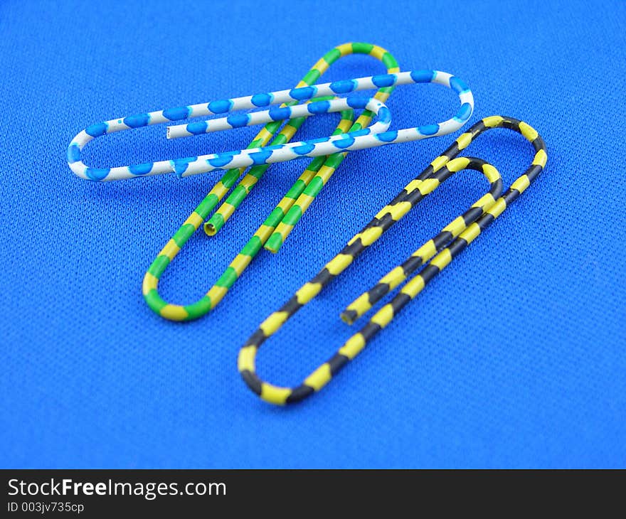 Colorful paper clips on a blue mat