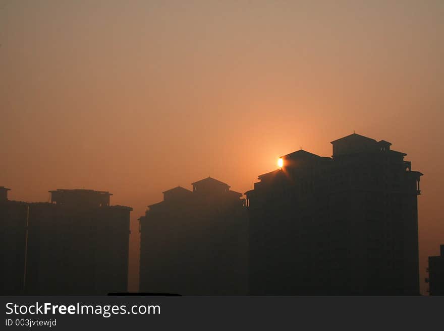 Sunsets behind a skyscraper high rise building eclipsing it in Gurgaon India. Sunsets behind a skyscraper high rise building eclipsing it in Gurgaon India