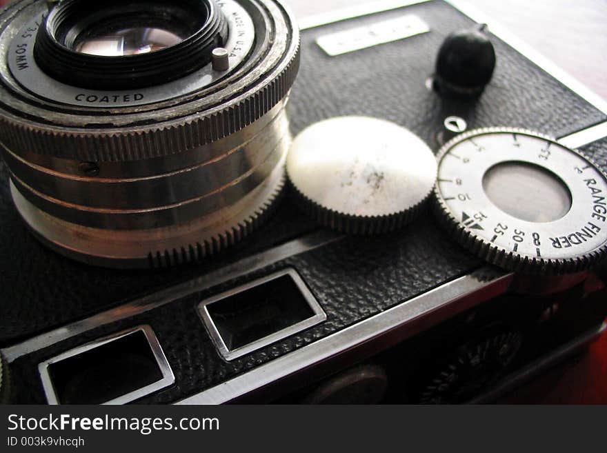 Vintage rangefinder camera ca. 1939 shown on a cherry wood desk in hard focus. Vintage rangefinder camera ca. 1939 shown on a cherry wood desk in hard focus.