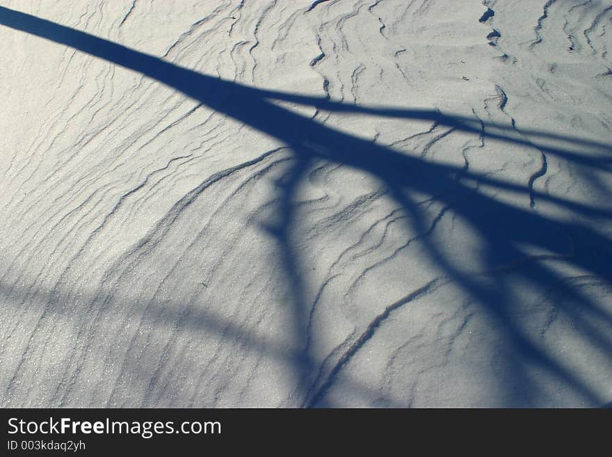 A starkly cold snowy day, contrasting the snow is the shadow of a tree. A starkly cold snowy day, contrasting the snow is the shadow of a tree.