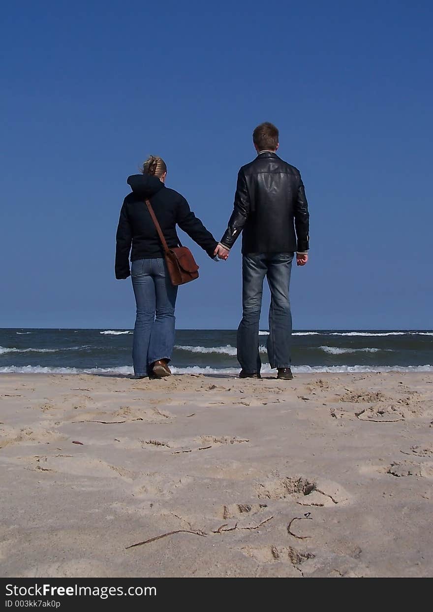 A couple is walking on the beach