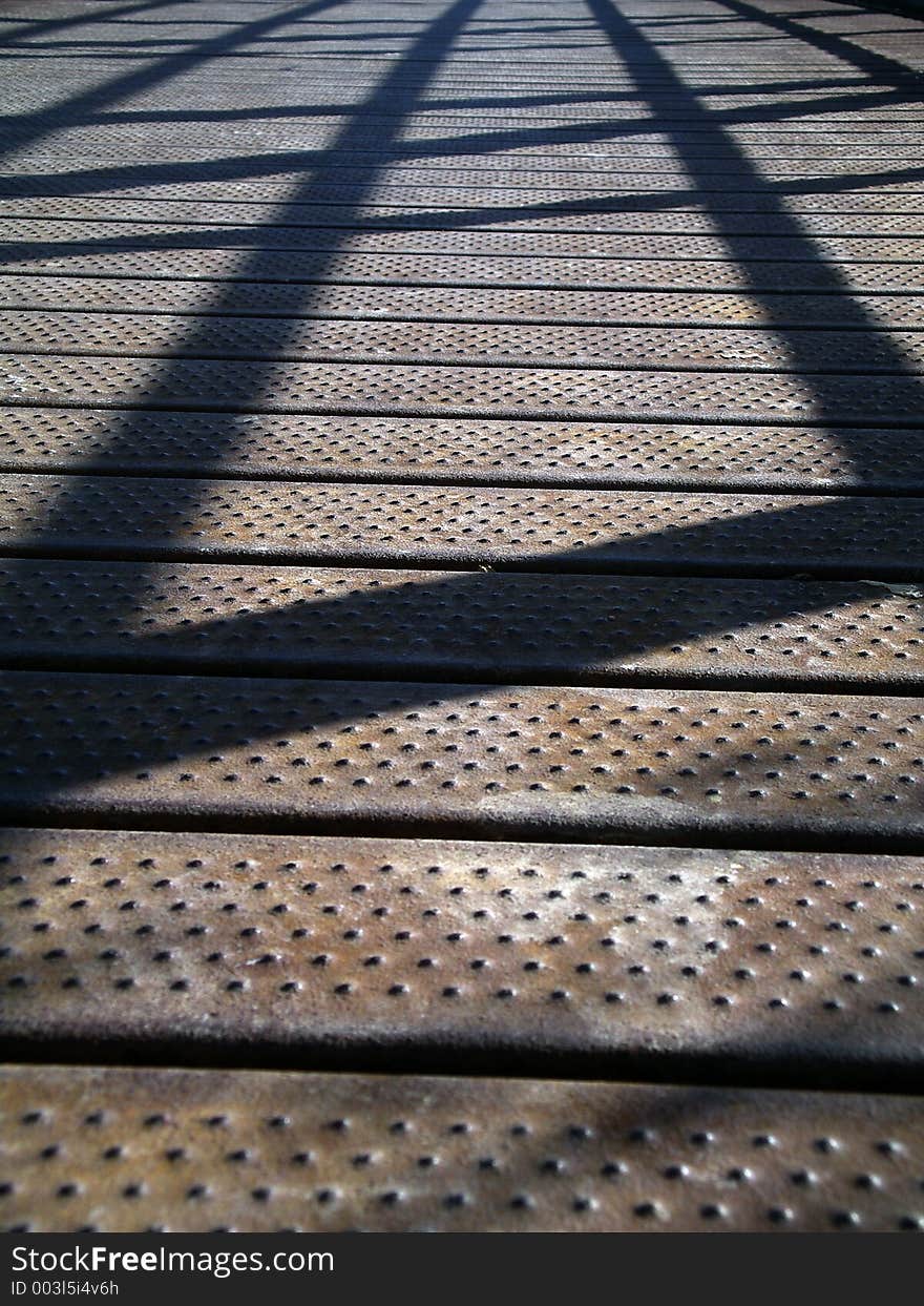 Shadows on a bridge made of metal. Shallow depth of field. Shadows on a bridge made of metal. Shallow depth of field.