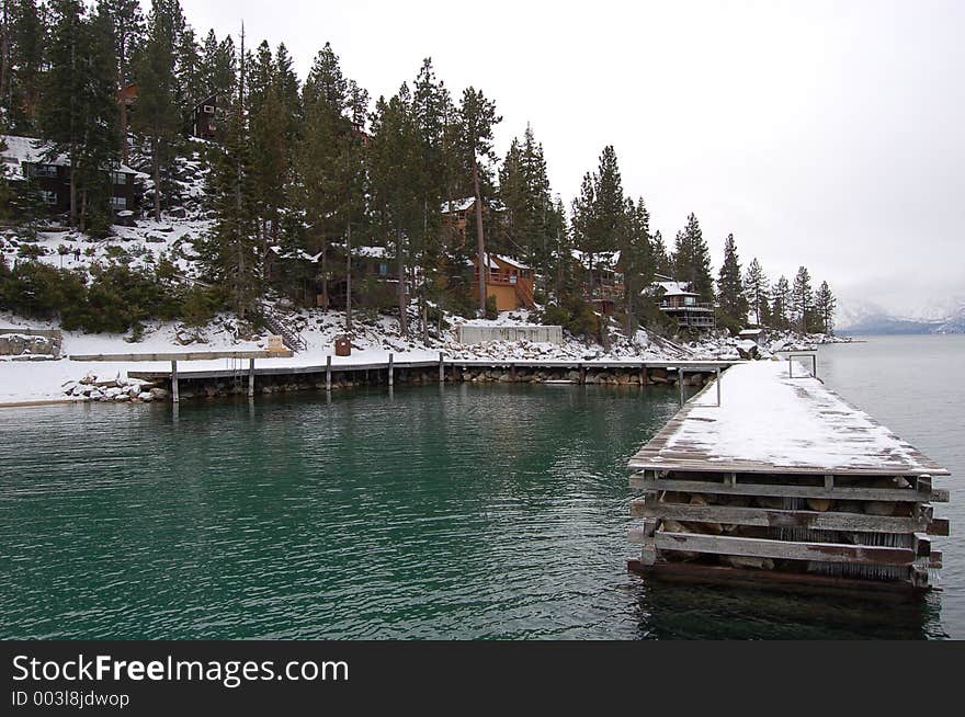 Dock on Lake Tahoe with view of cabins along the shoreline. Dock on Lake Tahoe with view of cabins along the shoreline.