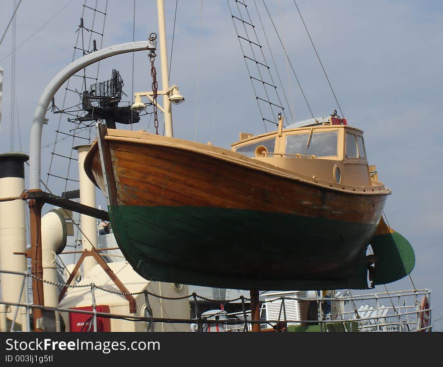 A boat hanging in the air off a ship. A boat hanging in the air off a ship.