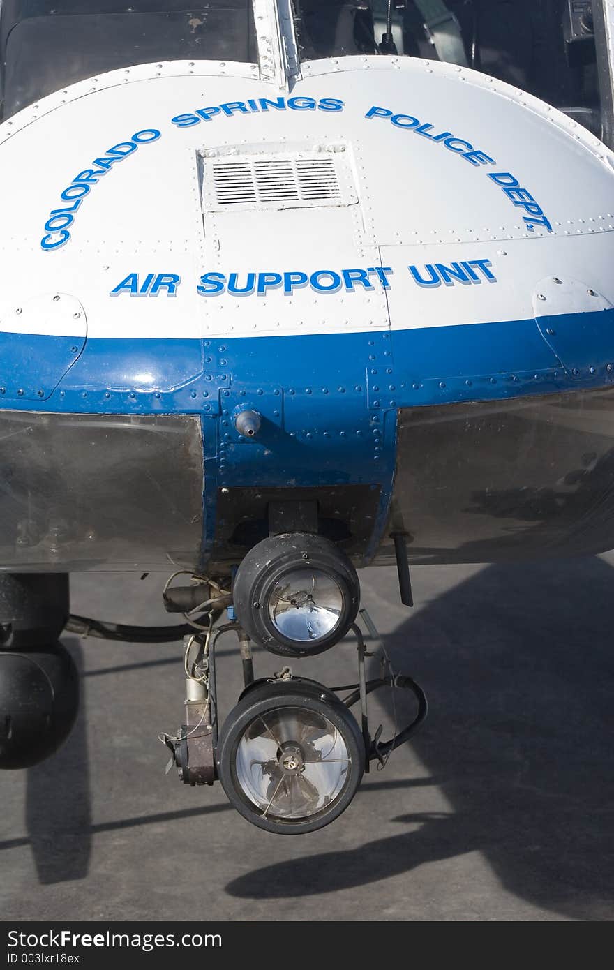 Closeup of the nose of a blue and white police helicopter, with the nightsun spotlight mounted. Closeup of the nose of a blue and white police helicopter, with the nightsun spotlight mounted.