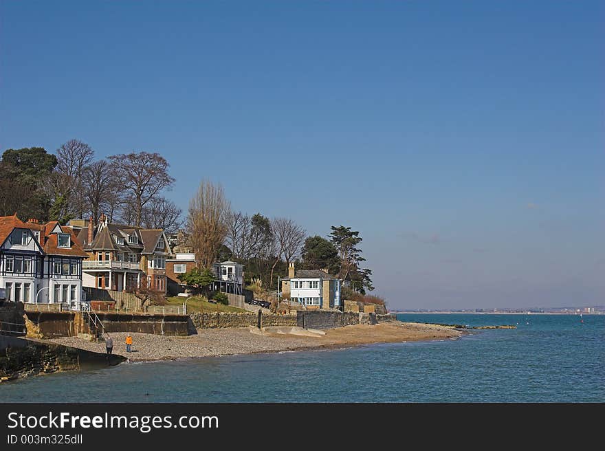 Homes next to beach with blue sea & sky on sunny day. Homes next to beach with blue sea & sky on sunny day