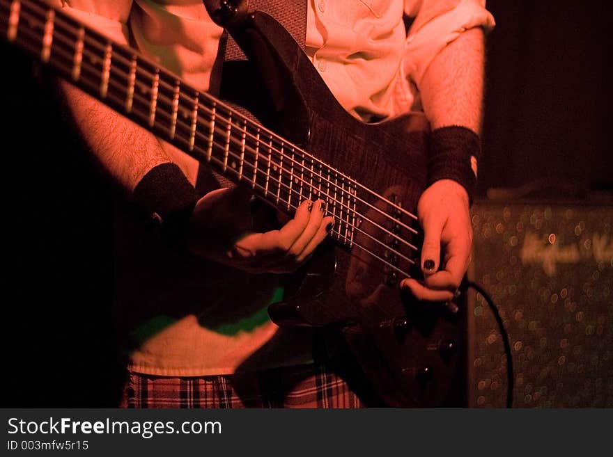 Detail shot of a guitarist performing on stage. Detail shot of a guitarist performing on stage.