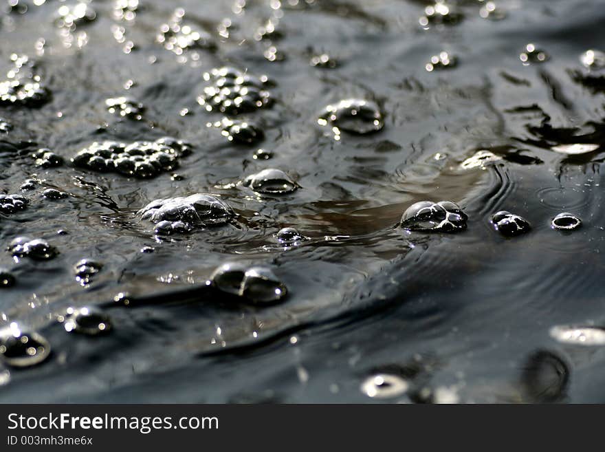 Water flowing by with bubbles on the surface