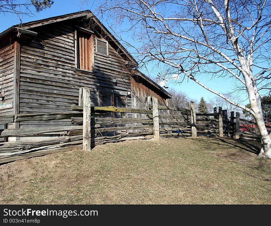 An old barn with dry grass in front of it