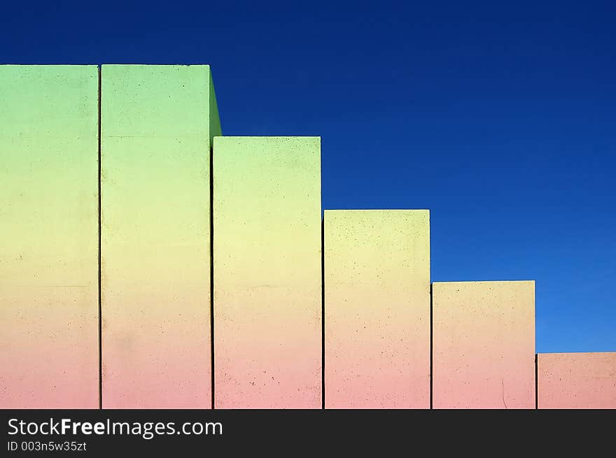 Concrete stairs shaped as chart on blue sky background colored from red to green. Concrete stairs shaped as chart on blue sky background colored from red to green