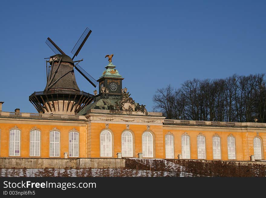 Historical windmill with the Orangerie Castle in the garden of Sanssouci in winter