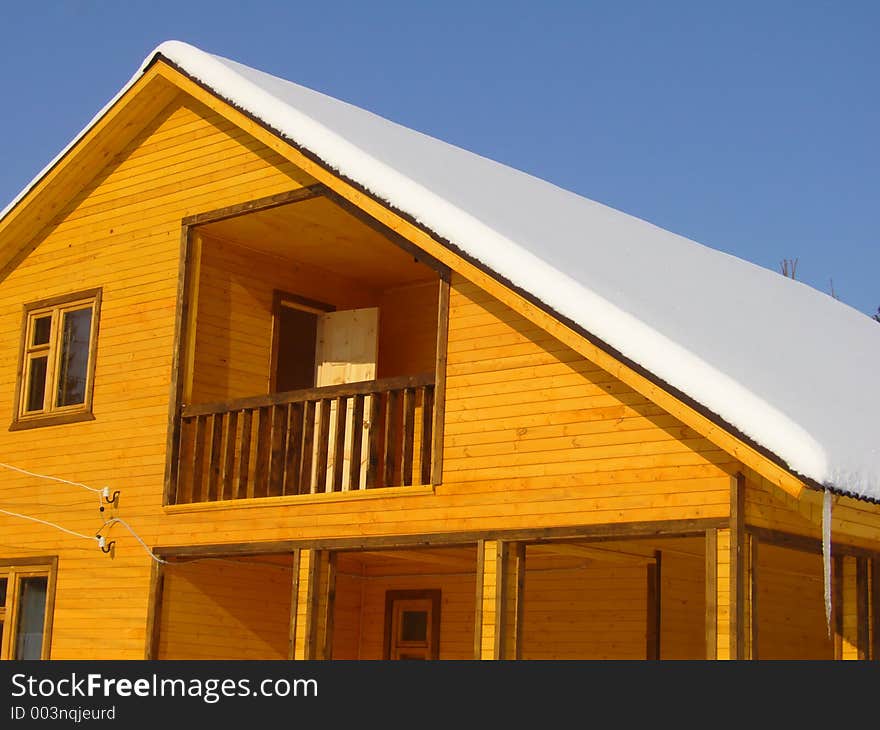 New wooden winter house over the blue sky. New wooden winter house over the blue sky