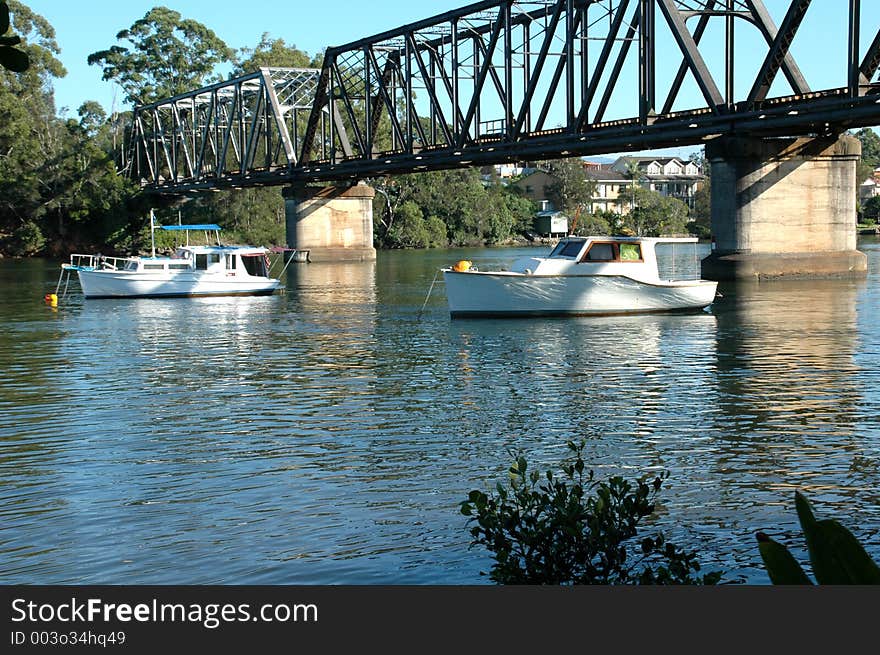 Two boats moored under the bridge