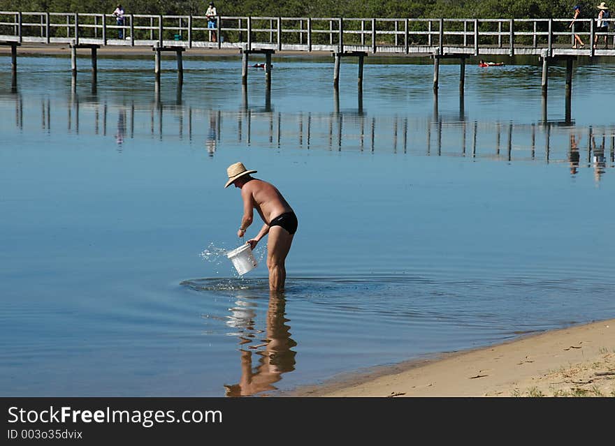 Man Filling A Bucket With Water