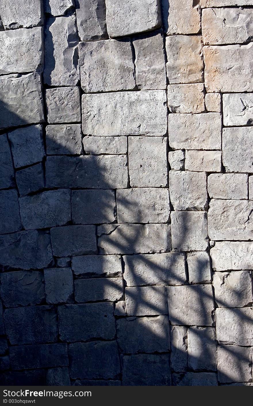 Deep shadows on a tiled stone wall