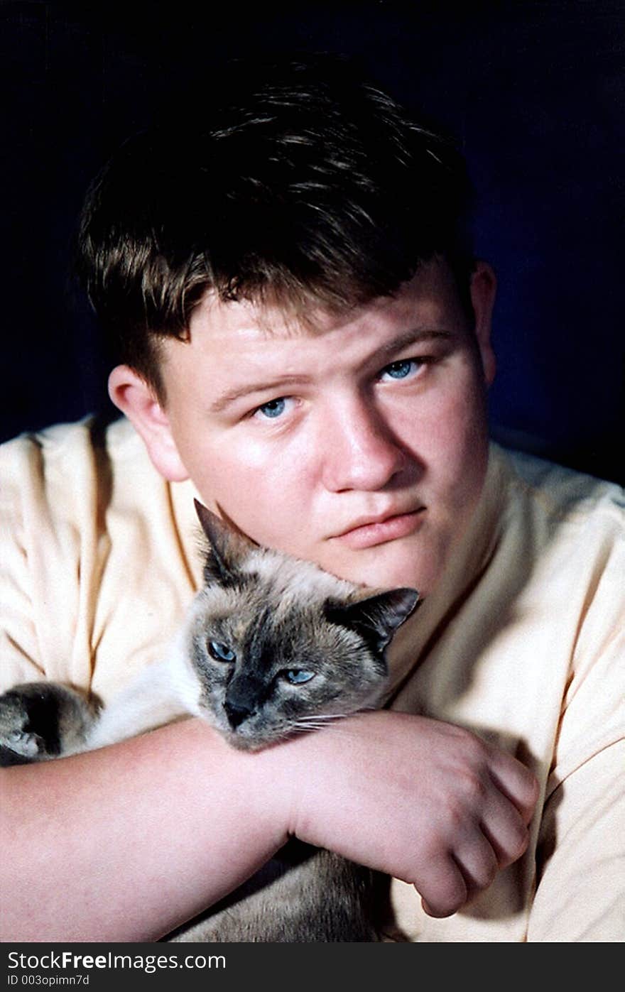 Teenage boy holding a Siamese cat. Teenage boy holding a Siamese cat.