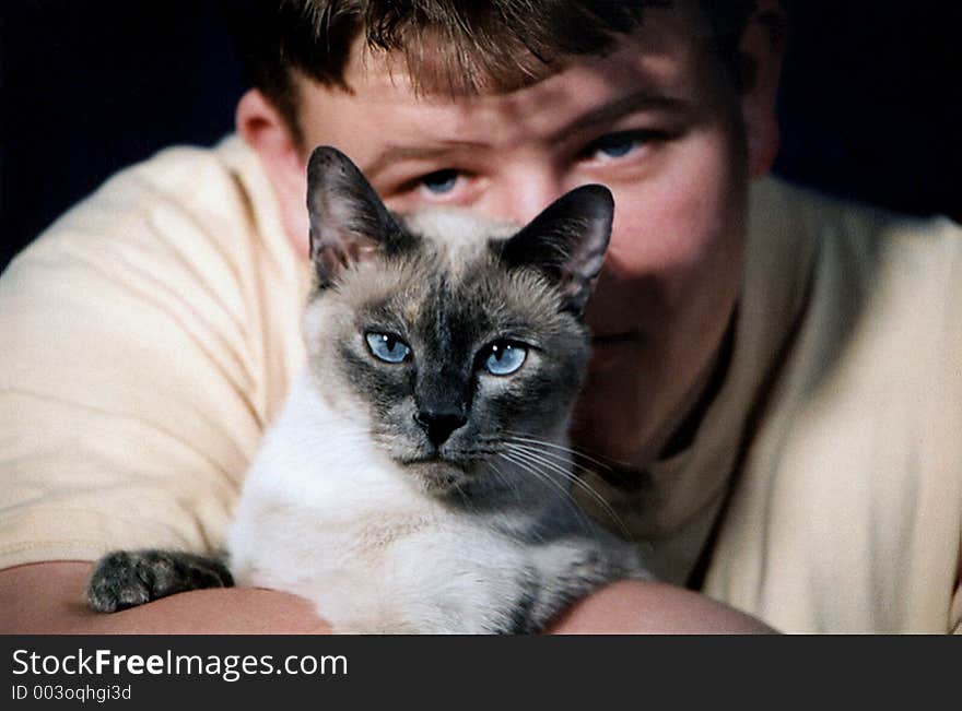 Teenage boy and Siamese cat. Teenage boy and Siamese cat.