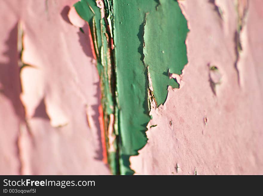 Old green paint showing through flaking pink layer. Old green paint showing through flaking pink layer