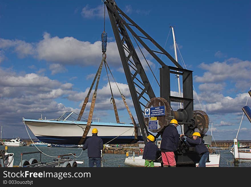 Family lowering boat into water