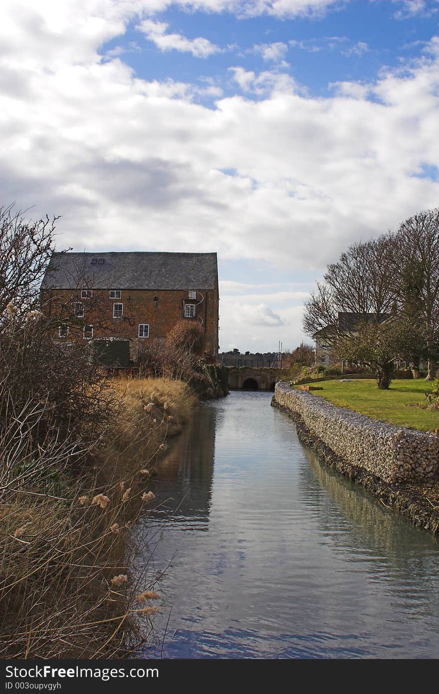 Old brick mill house and mill stream on sunny day. Old brick mill house and mill stream on sunny day