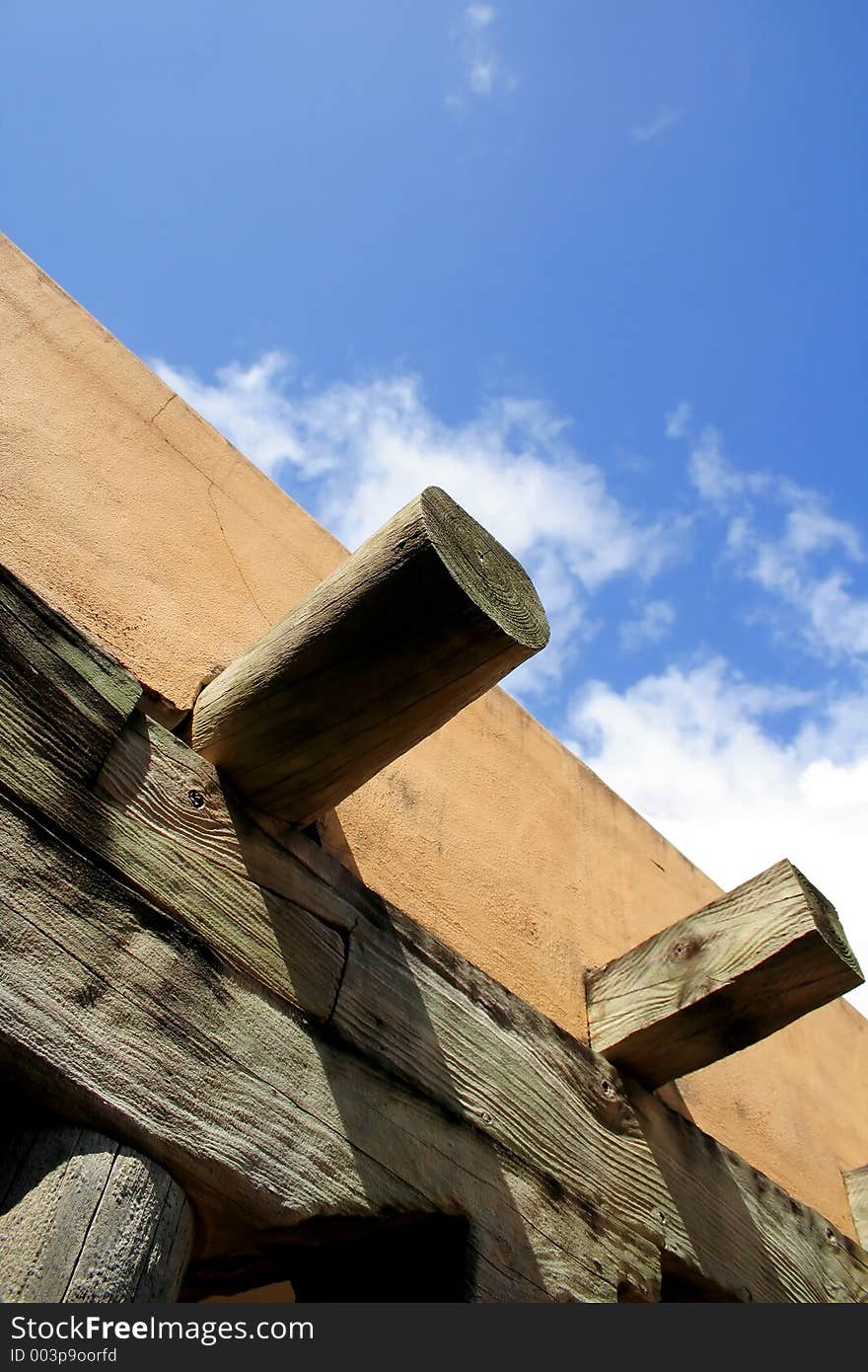 Broad sky and partial view of an adobe and timber building. Broad sky and partial view of an adobe and timber building.