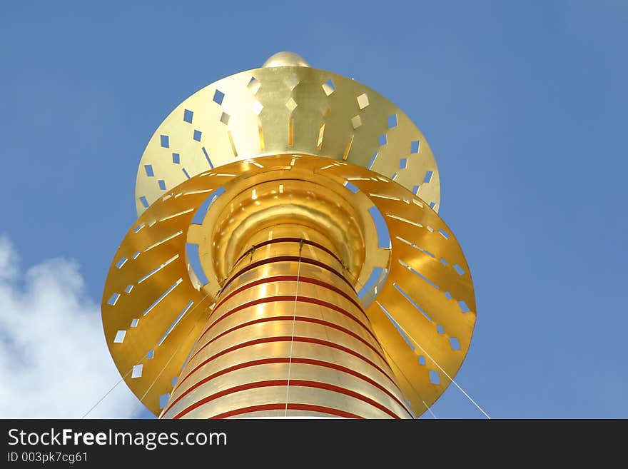 Decorative gold top on a mosque against a blue sky