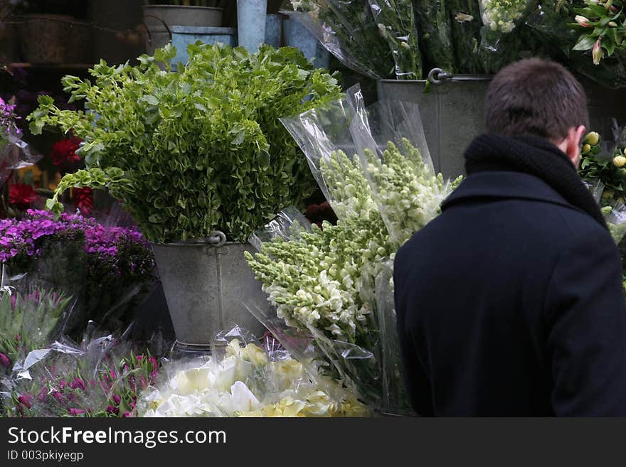 Man shopping for flowers at a outdoors flowerstand. Man shopping for flowers at a outdoors flowerstand