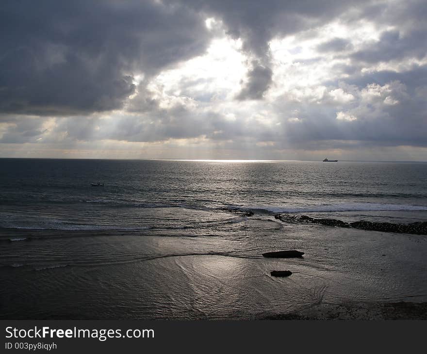 Seaside landscape with sun hiding behind clouds. Seaside landscape with sun hiding behind clouds