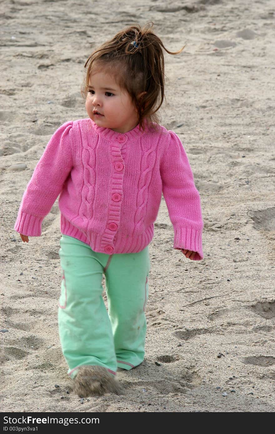 Toddler walking through the sand. Toddler walking through the sand