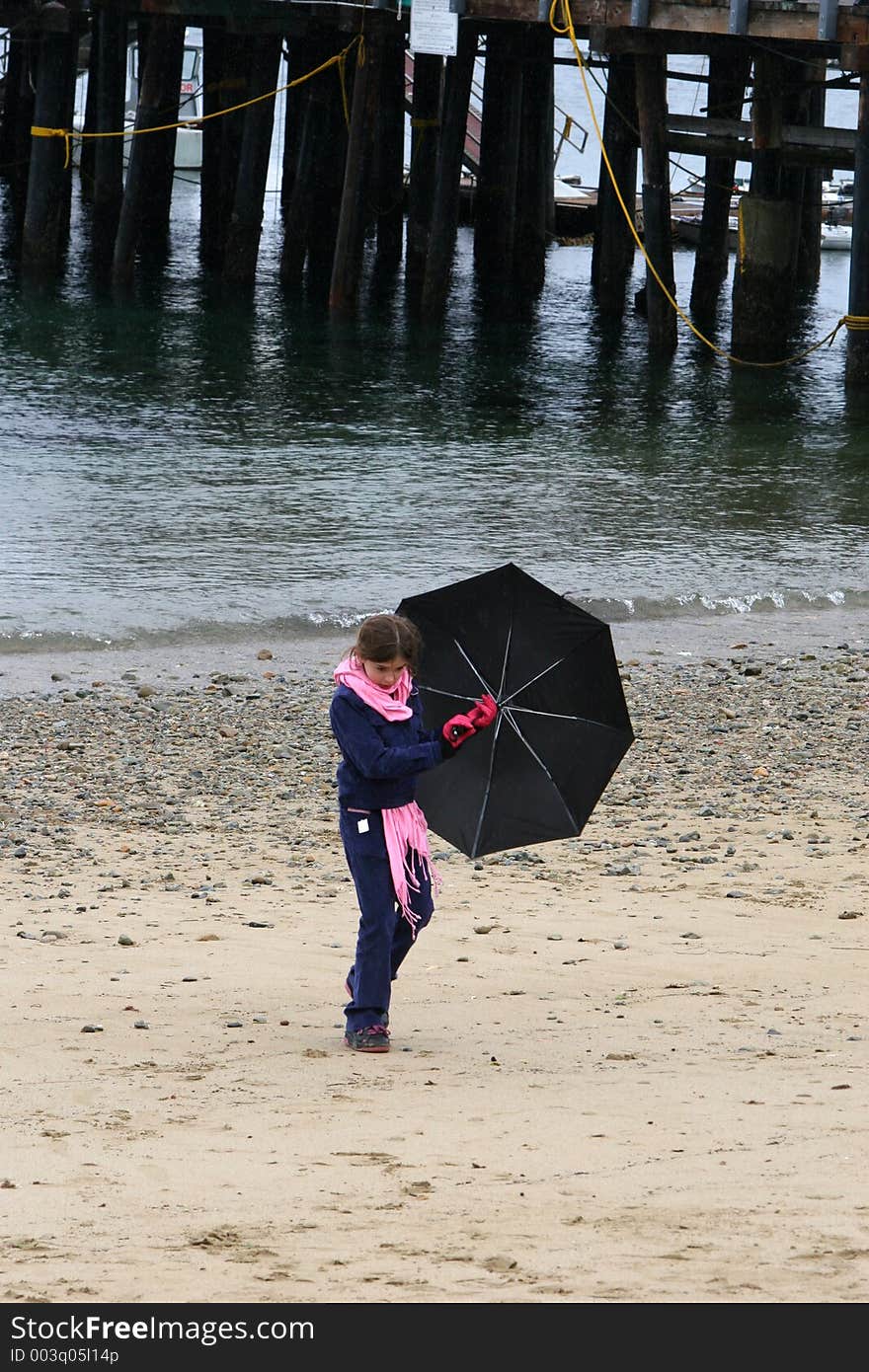 Child walking on the beach and holding an umbrella. Child walking on the beach and holding an umbrella