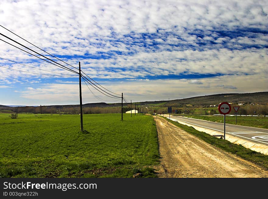 Road across a green field. Road across a green field.