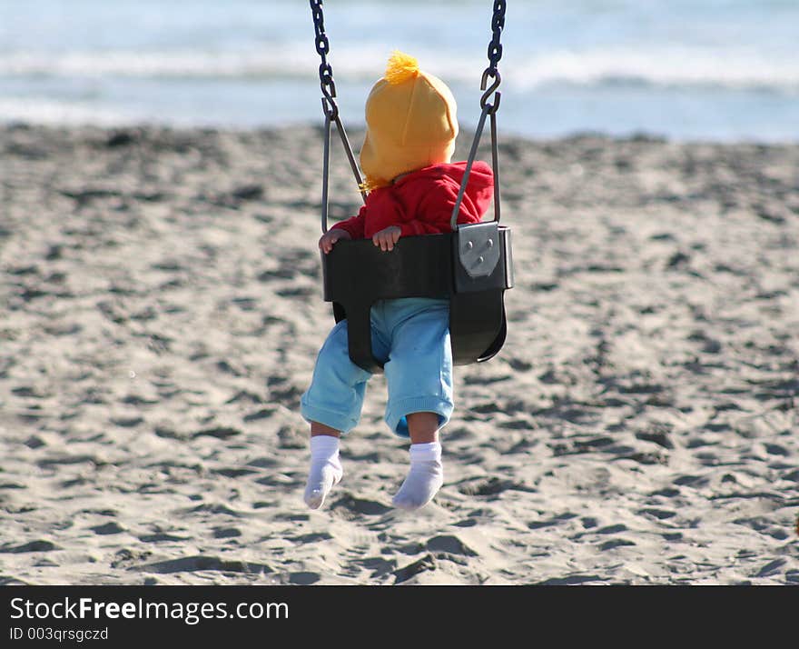 Baby on a swing at the beach in Oceanside, California. Baby on a swing at the beach in Oceanside, California