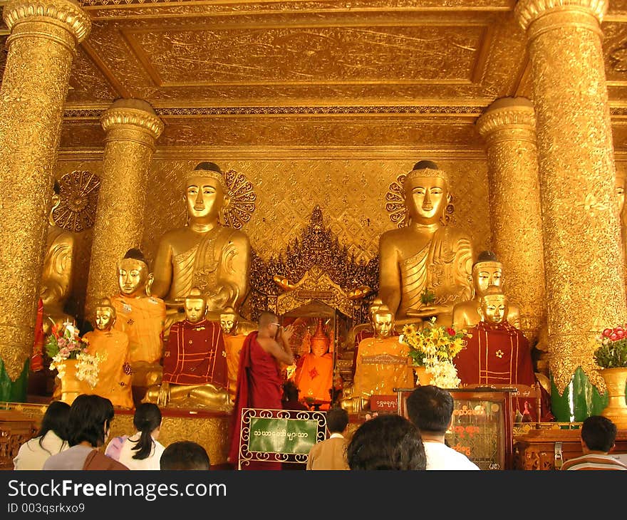 Monk and worshippers in Shwedagon Pagoda, Yangon, Myanmar