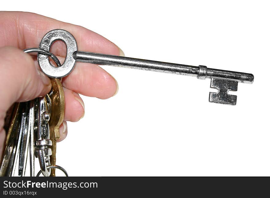 A large key on a bunch of keys isolated over a white background. A large key on a bunch of keys isolated over a white background