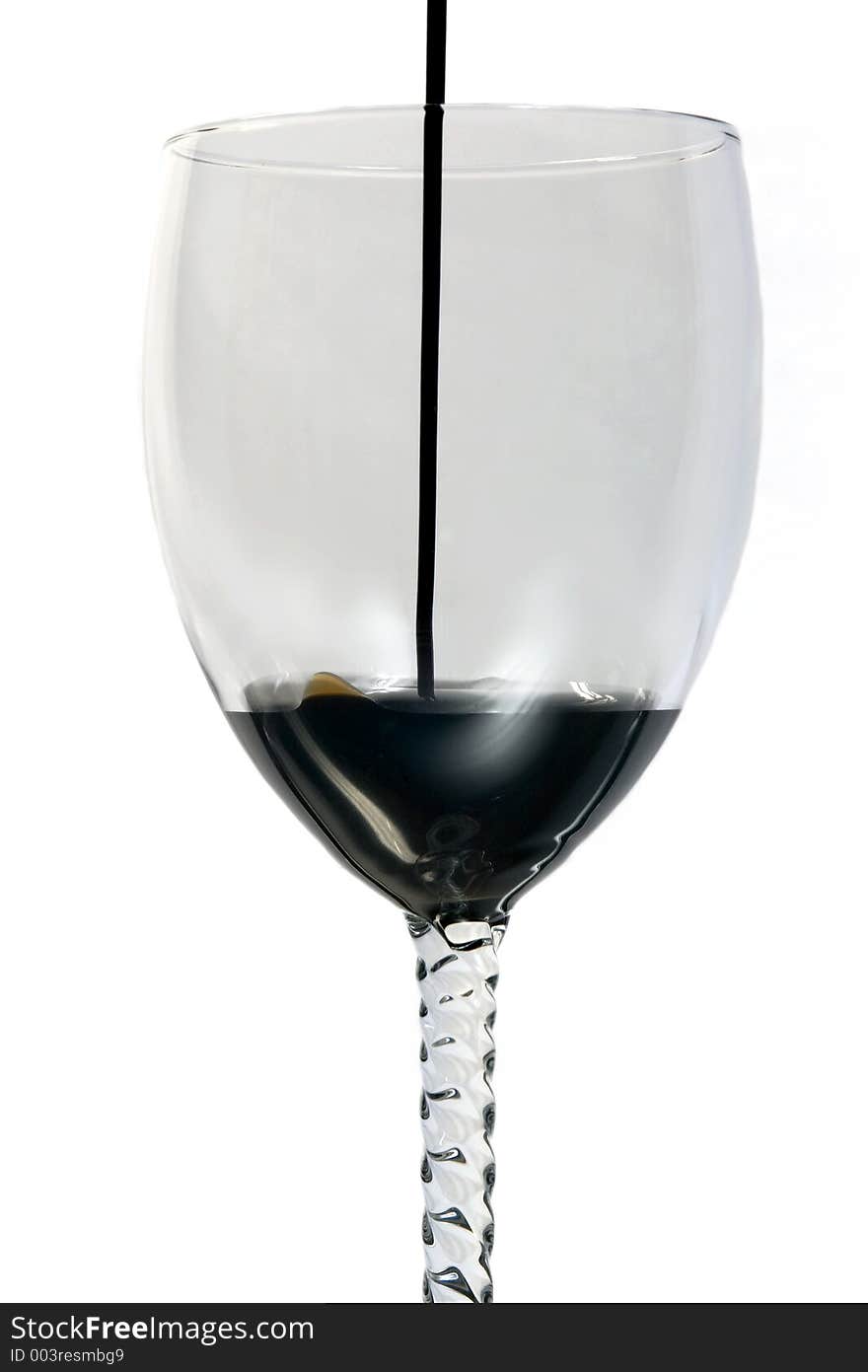 Oil being poured into a wine glass. Oil being poured into a wine glass