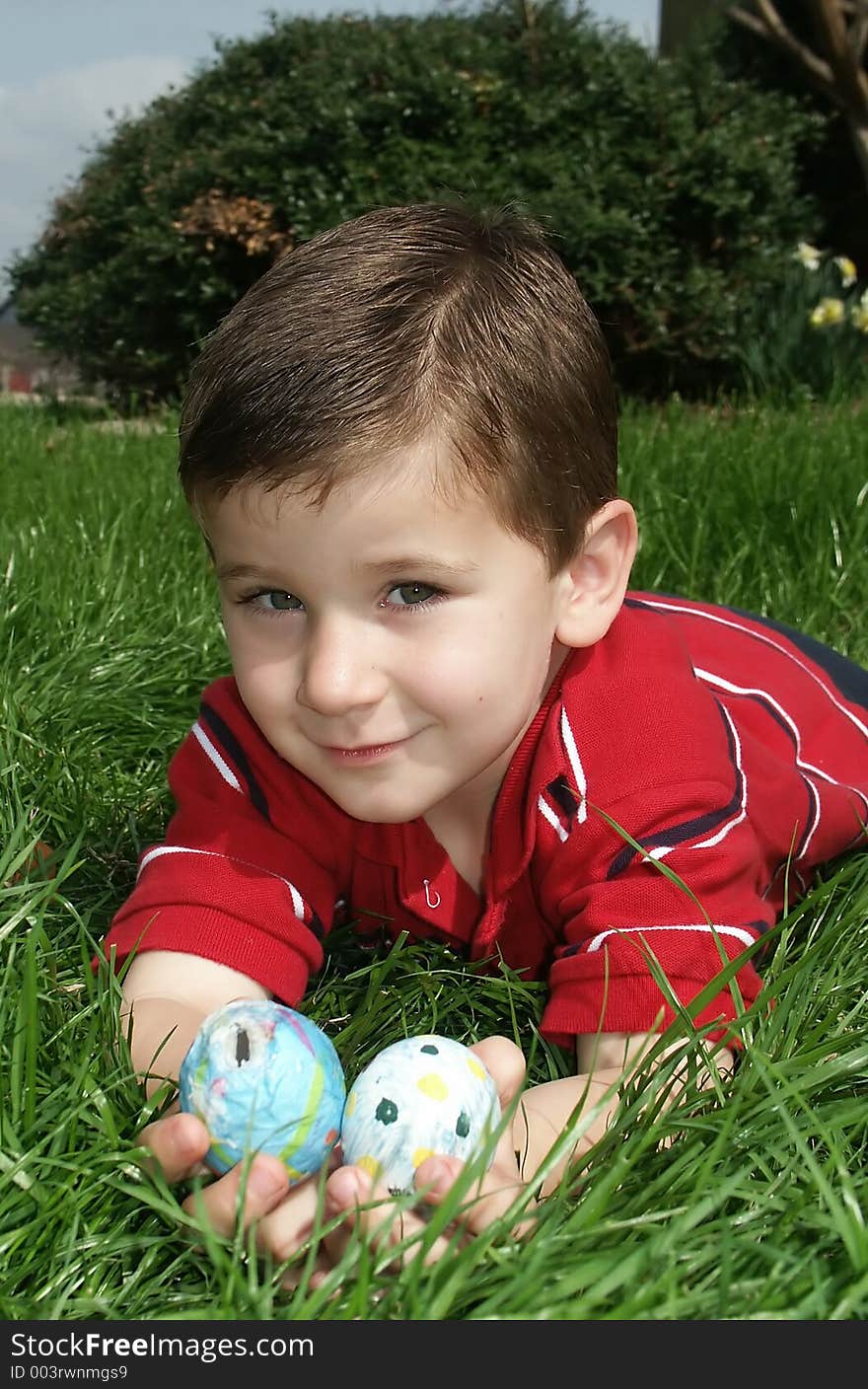 A young boy showing off two Easter eggs. A young boy showing off two Easter eggs.