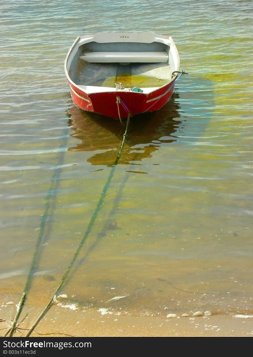 Small cheap weathered dingy floating in the water. Small cheap weathered dingy floating in the water