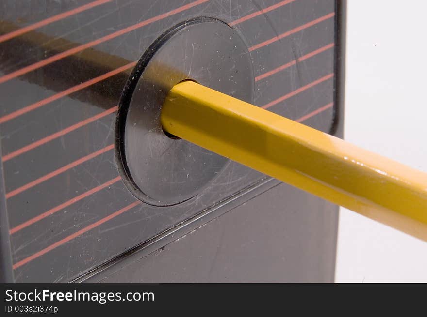 A close up view of a pencil inserted in an electric sharpener. A close up view of a pencil inserted in an electric sharpener