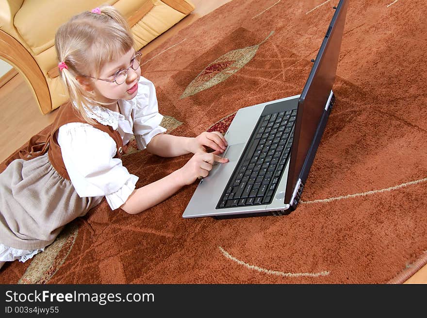 Little girl with laptop on the floor