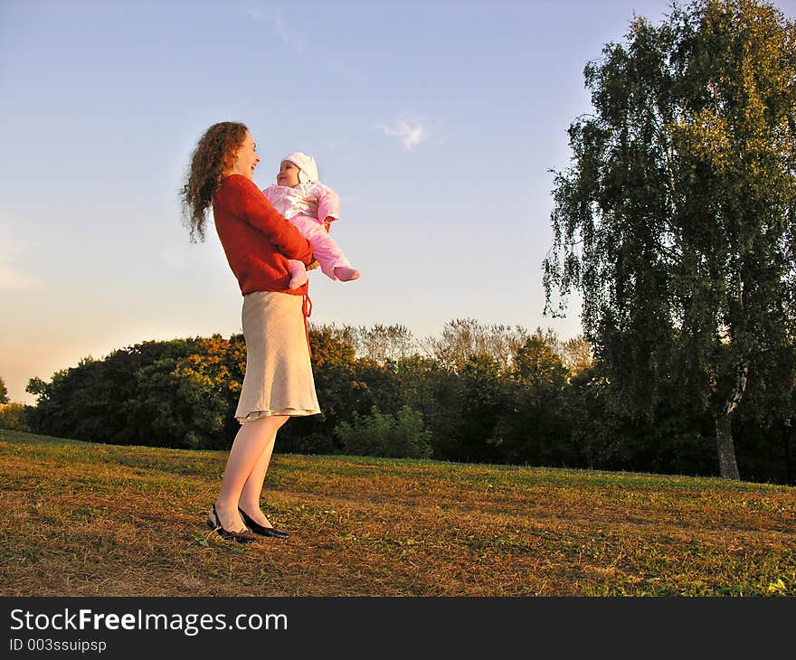 Mother with baby on sunset meadow